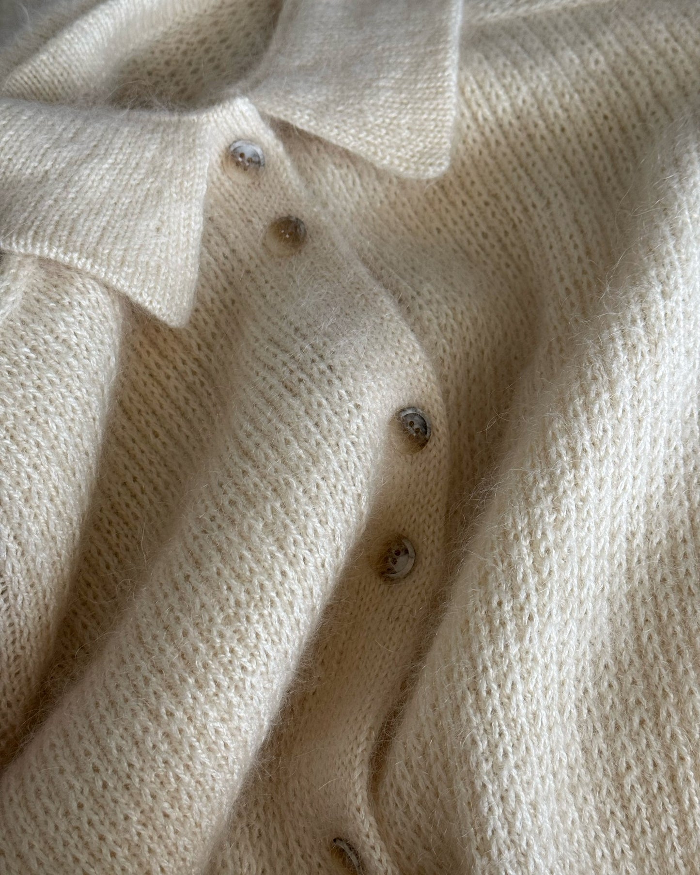 Action photo illustrating movement of modern basic cardigan with relaxed fit created using top down knitting method.