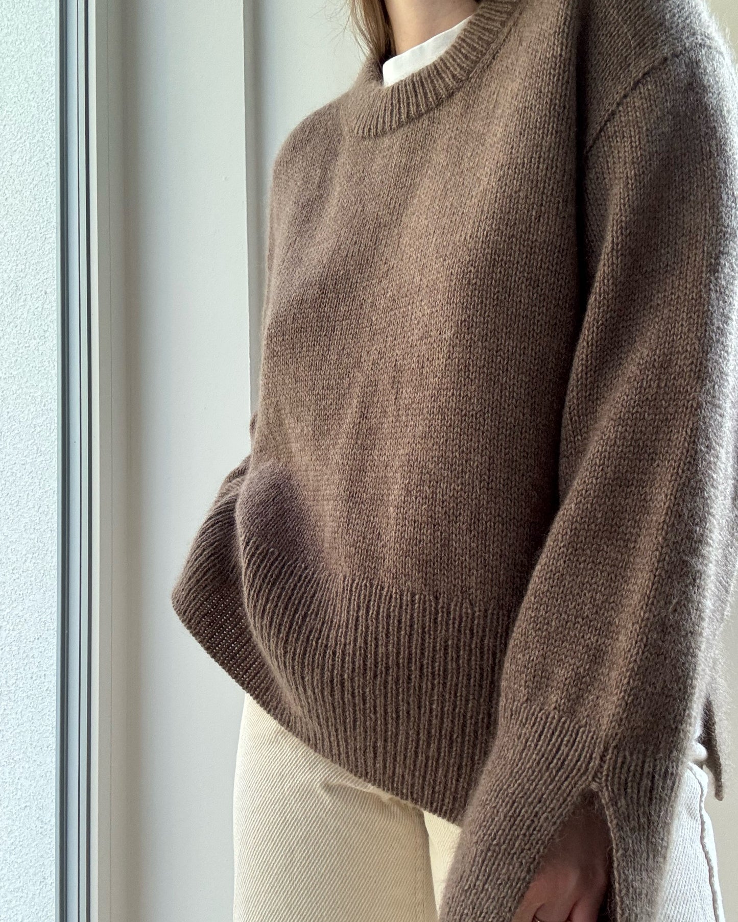 Front pose highlights rounded o neck and double knitting rib neckline with minimalist aesthetic.