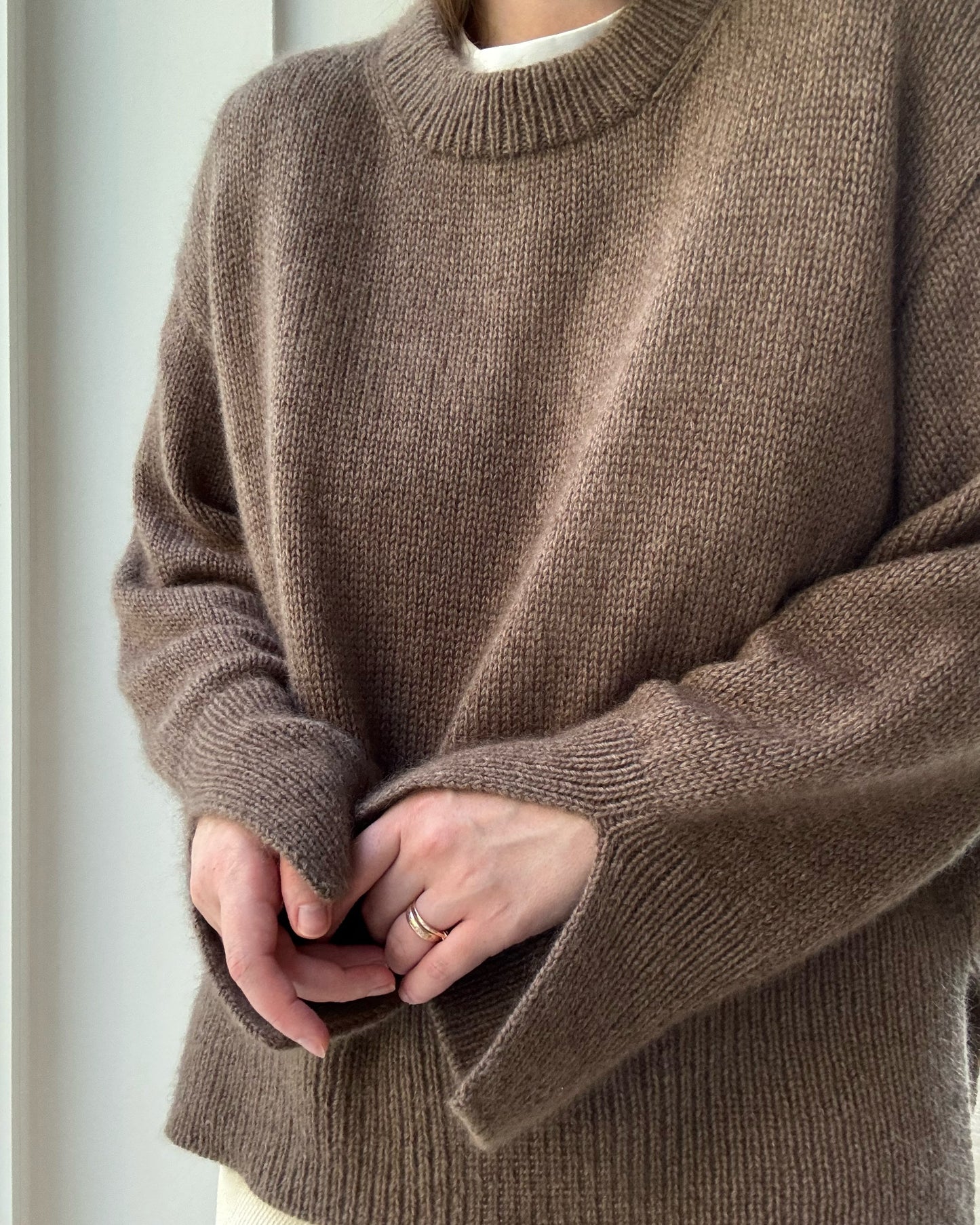 Relaxed stance displays oversized fit and side slits of the classic stockinette jumper from the Knit Guide.