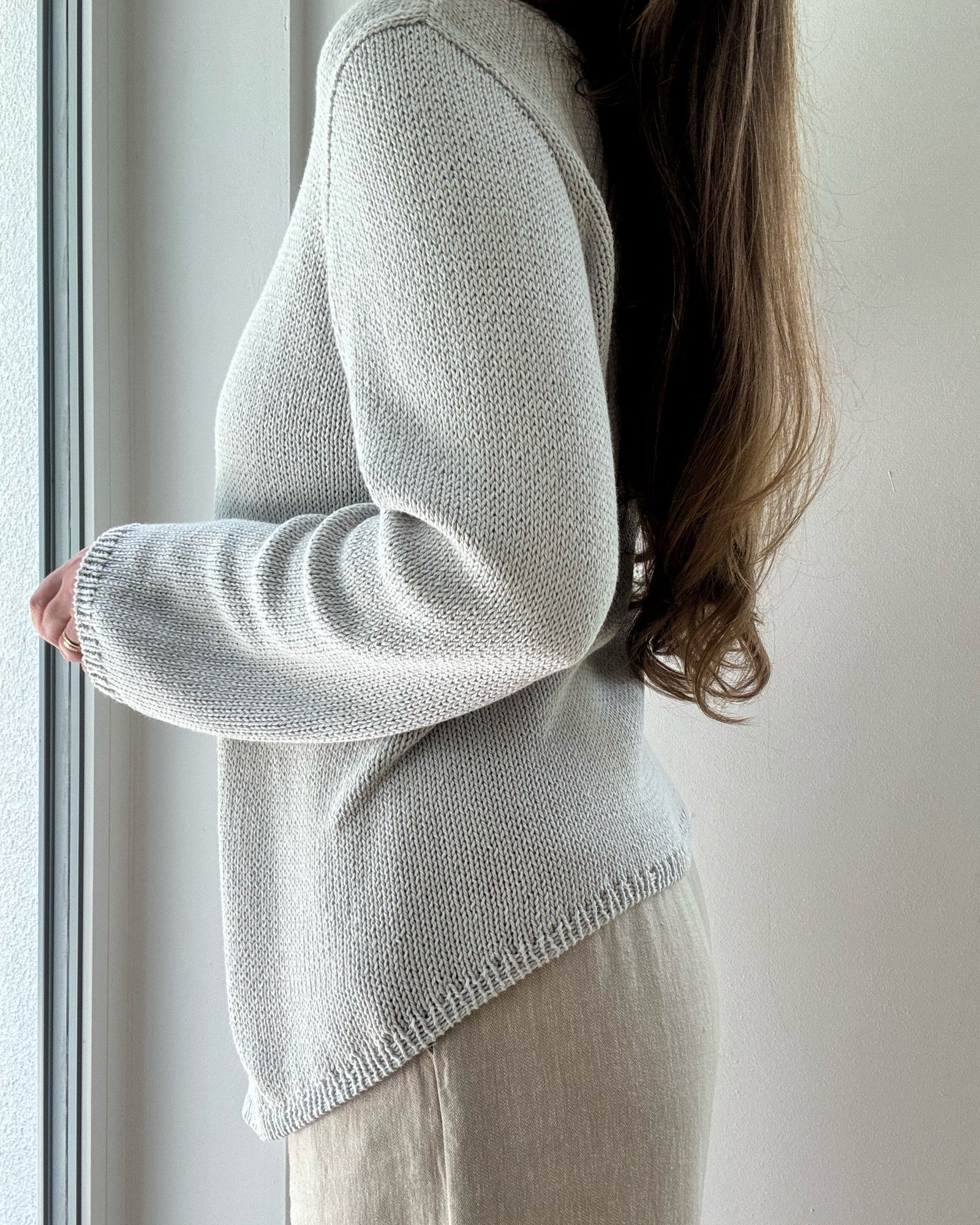 리브 블라우스는 평평하게 놓여 보트넥과 비대칭 탑다운 구성을 regular fit 면 린넨 실크 원사로 보여준다.