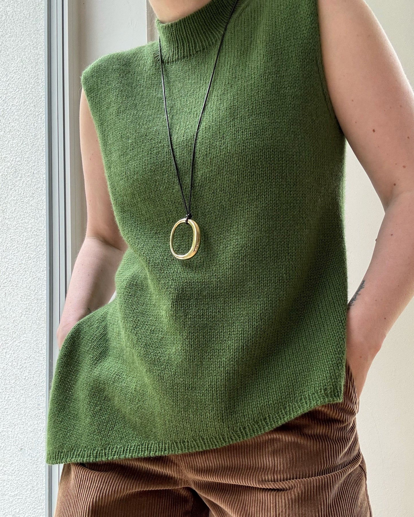 Detail image focuses on neckline transition between mock neck and rounded crew creating aesthetic minimal style.