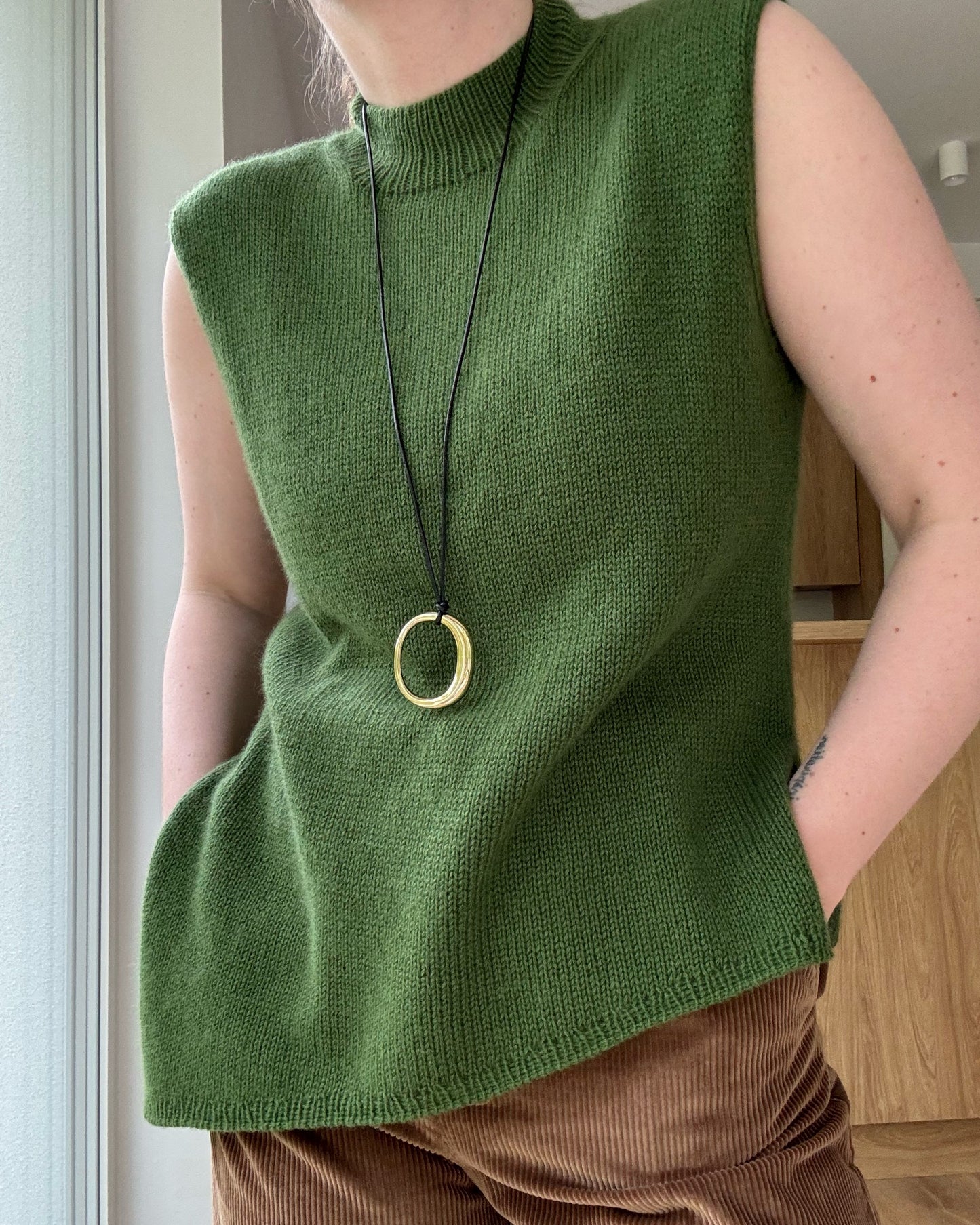 Detaljfoto fokuserar på övergång mellan mock neck och rund hals och skapar minimalistisk stil.