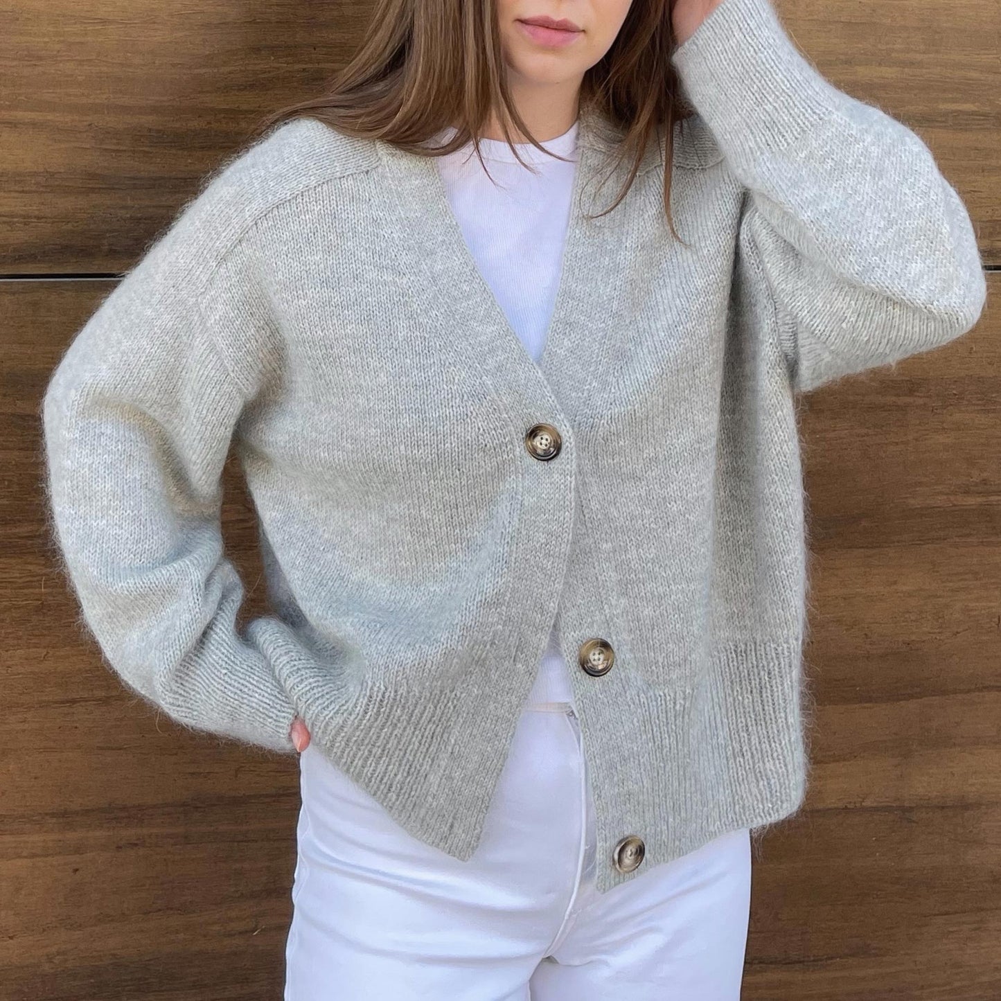 Foldet Paul Cardigan i grå, viser sit minimalistiske design og æstetik, strikket med en uld og mohair blanding