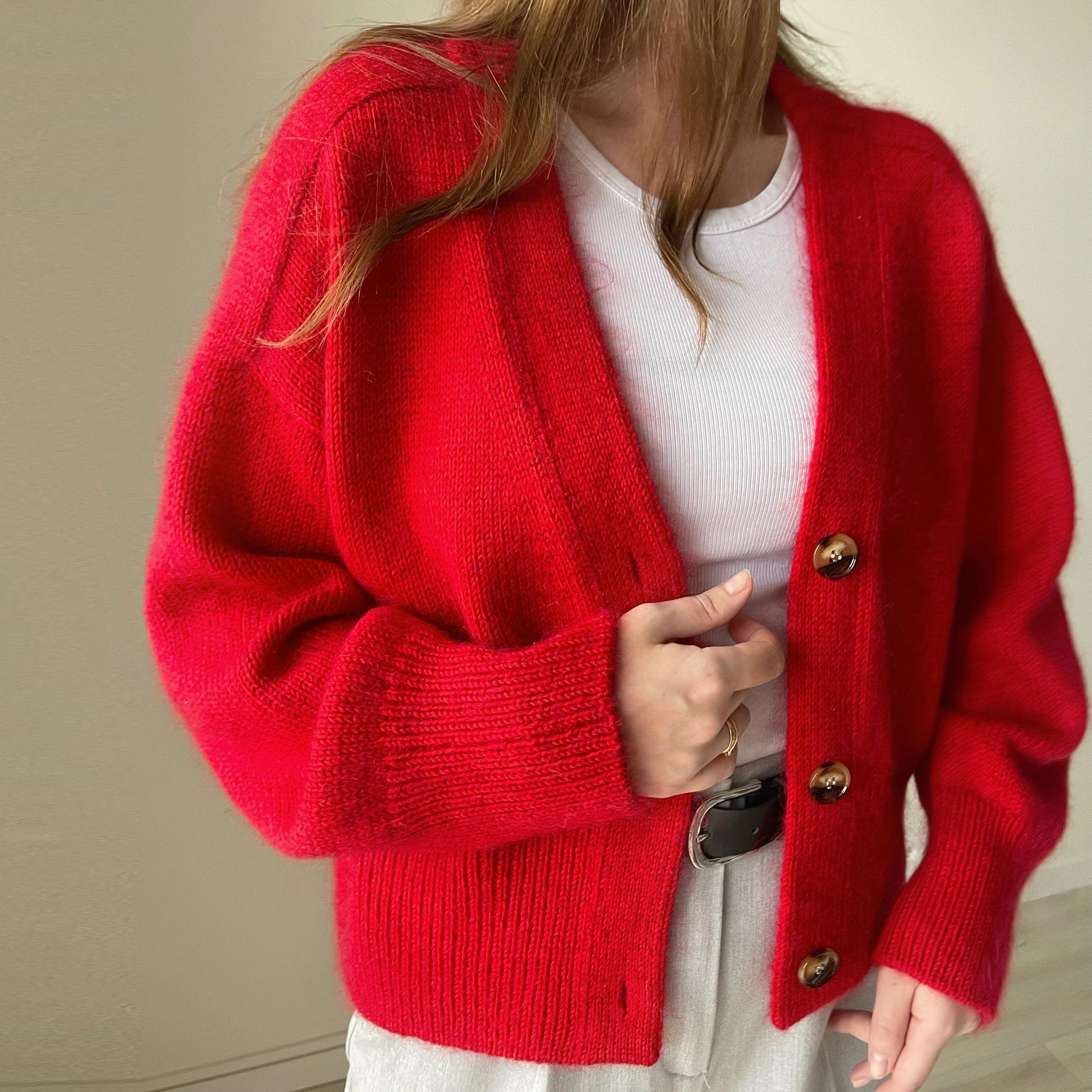 Nahaufnahme von Paul-Cardigans überschnittenen Schultern, zeigt die moderne Ästhetik des Musters, gestrickt in DK 11wpi Garn.