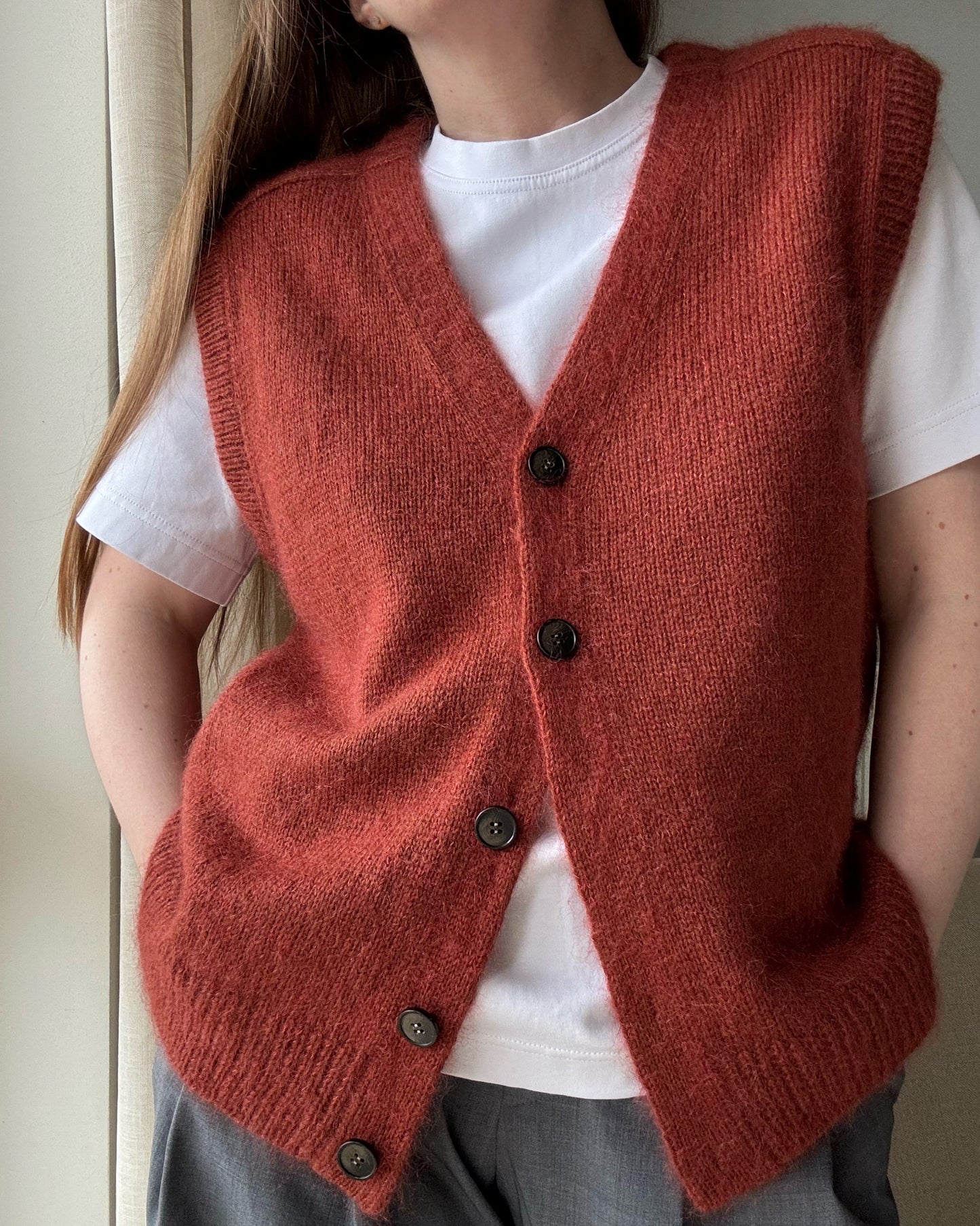 Ärmelloser Cardigan, gestrickt mit Knopfverschlussdetail und Top-Down-Stricktechnik, demonstriert einen einfachen und klassischen Stil.