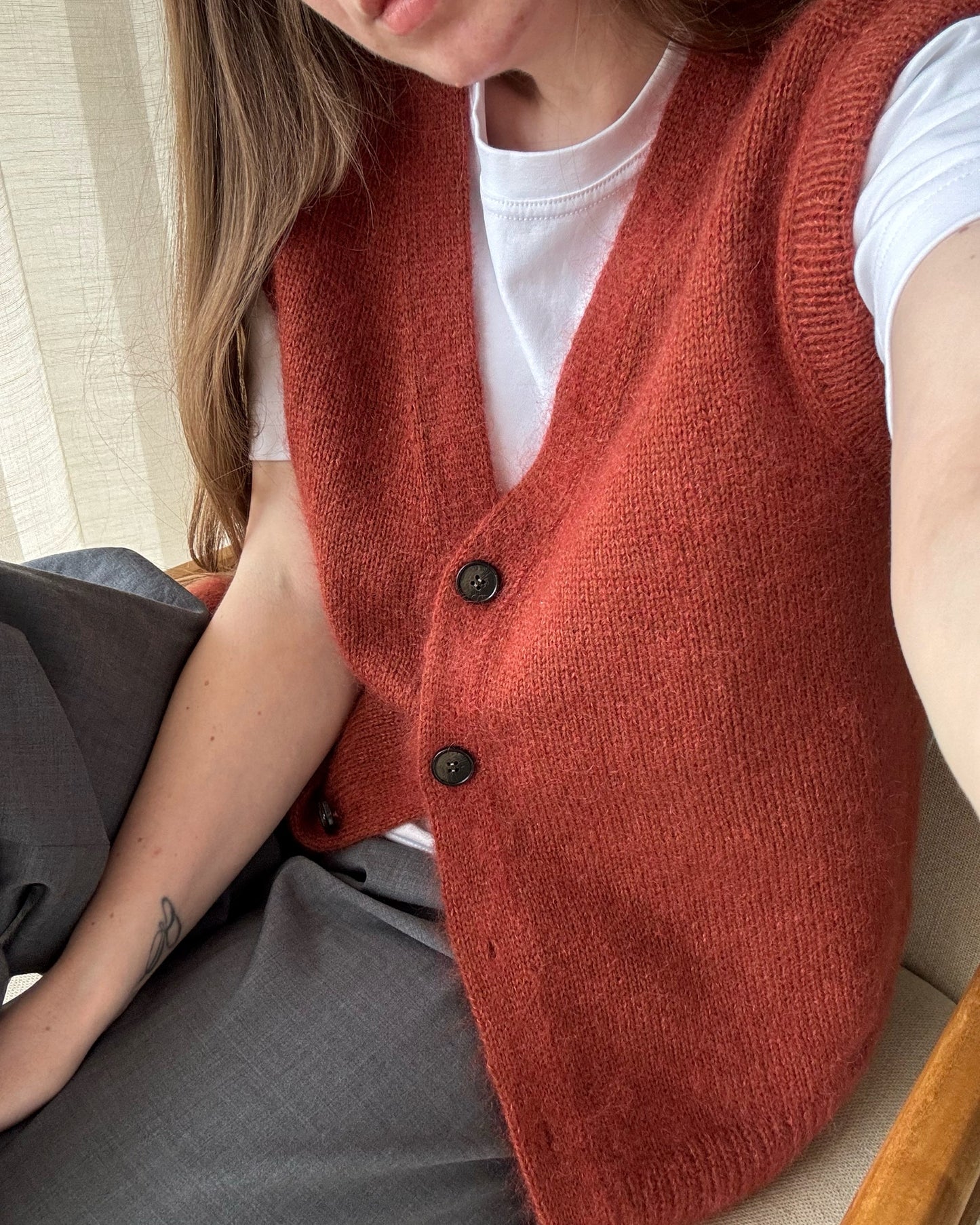 Avansert mønster for en ermeløs cardigan som kombinerer klassisk design med myke, glattstrikkede detaljer.