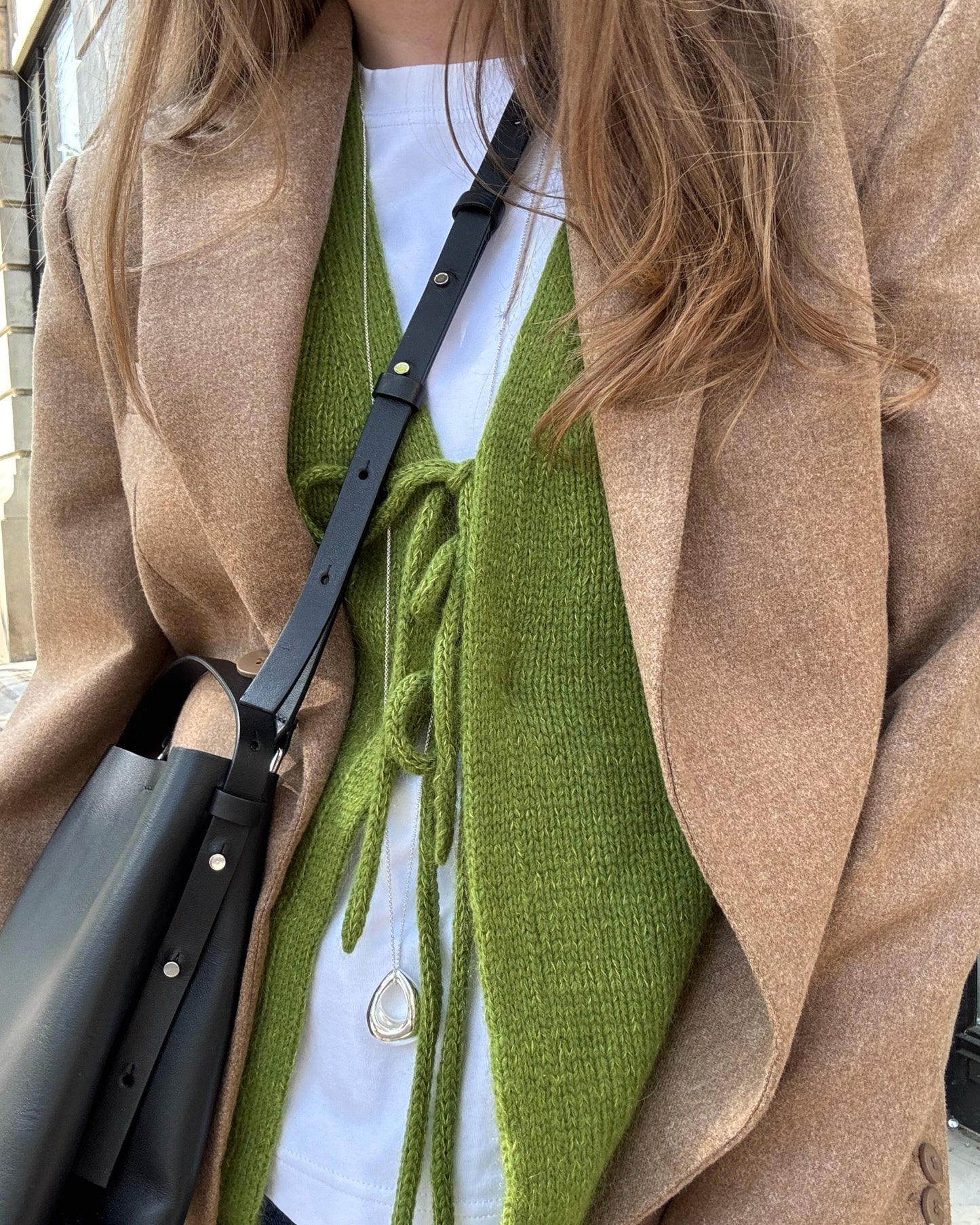 Photograph captures movement of classic soft vest emphasizing light feel provided by stockinette stitch.