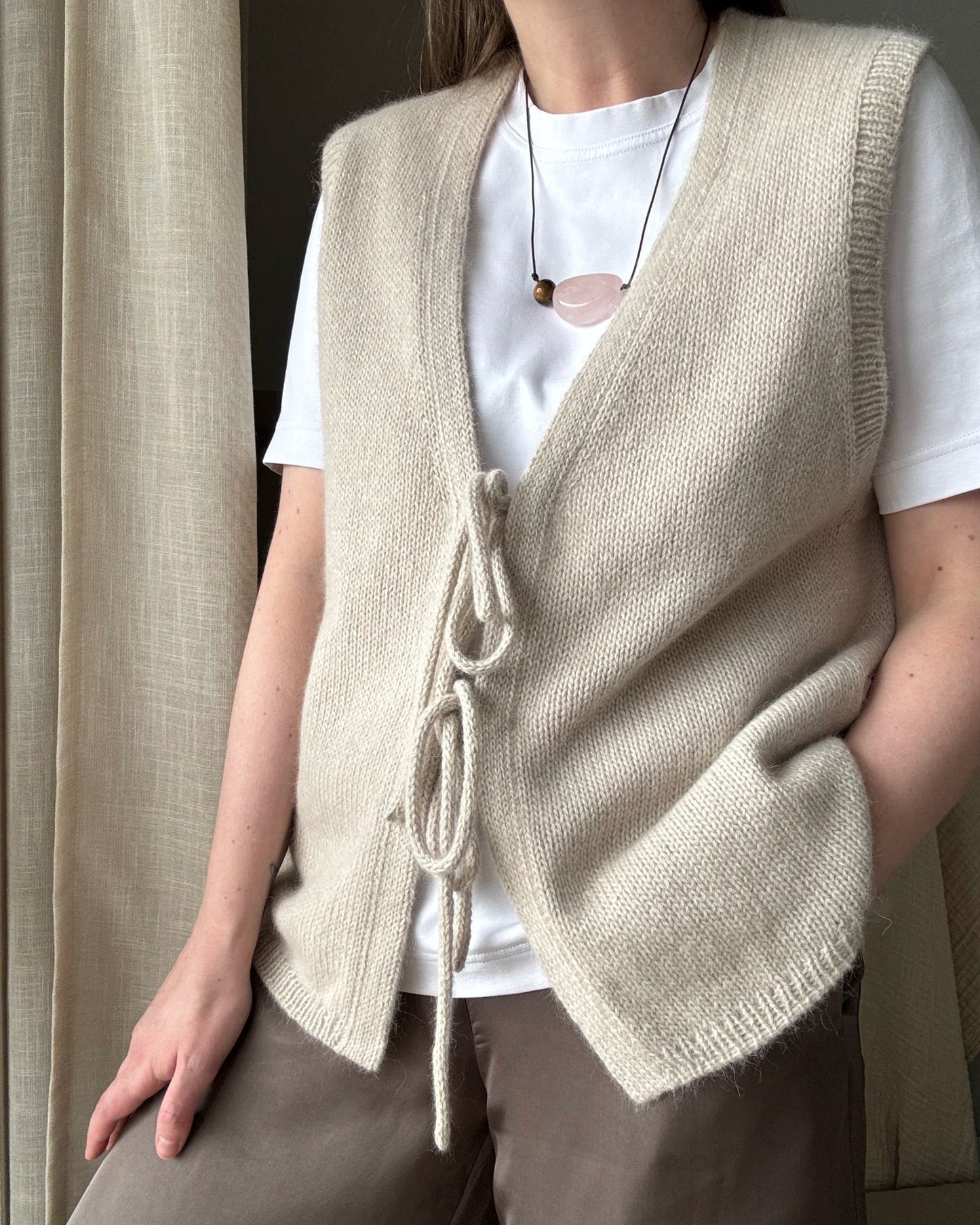 Solene Vest minimalist top down sleeveless cardigan knitted in merino wool and mohair displayed flat to show relaxed fit.