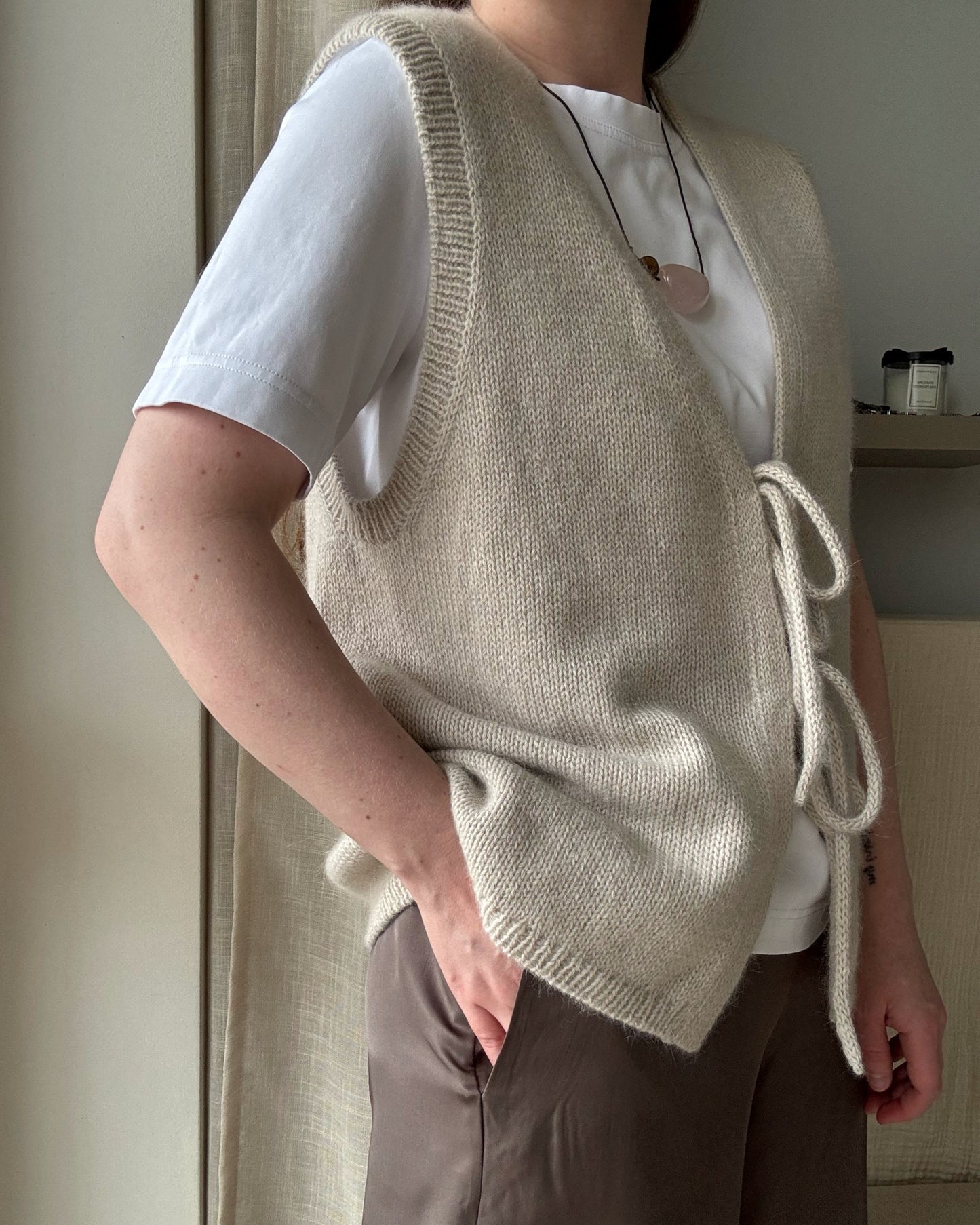 Back angle reveals elegant light drape and contemporary basic silhouette of Solene Vest knit guide for ladies.
