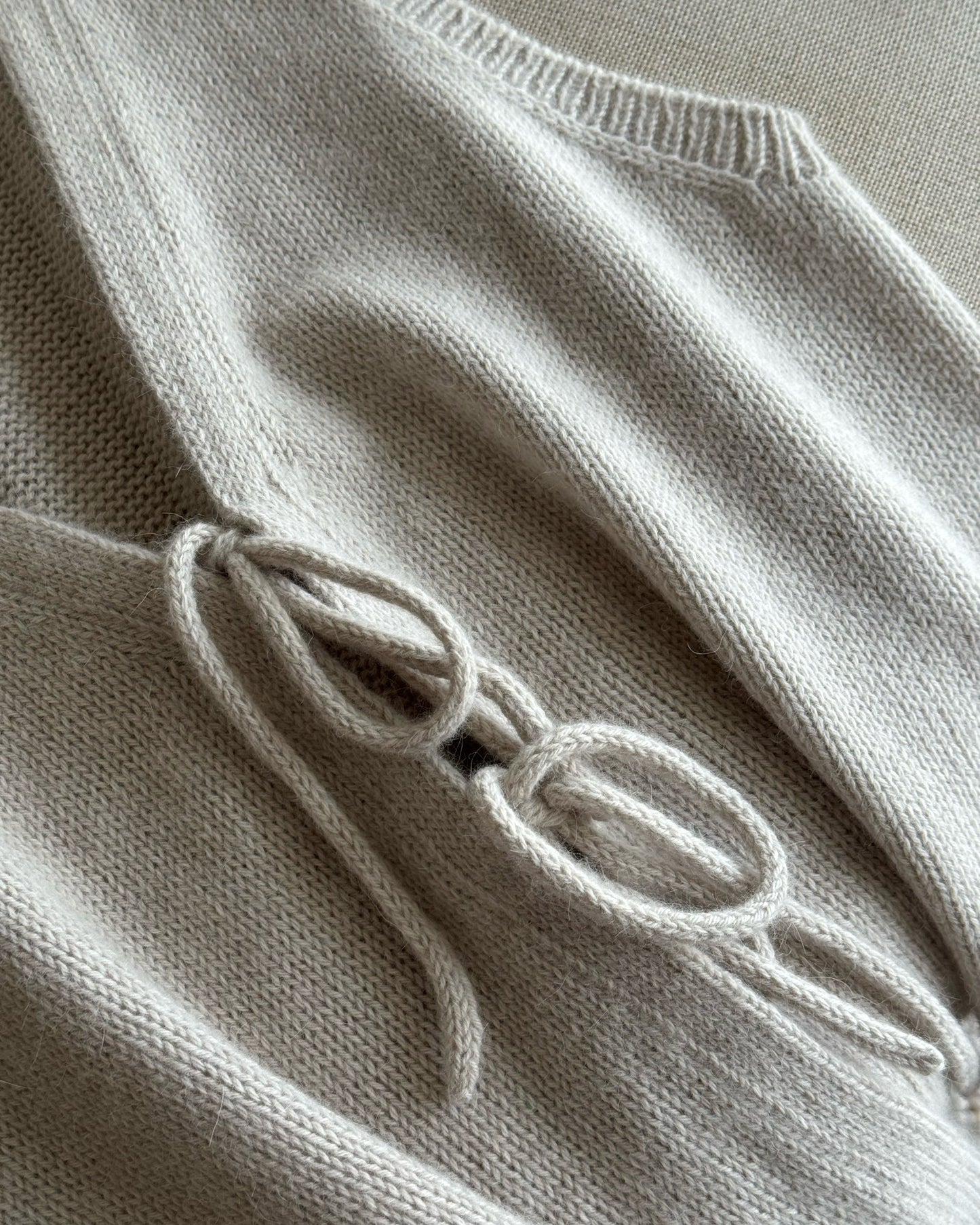 Detail image highlights clean double knitting edges and secure ties that shape the relaxed fit of Solene Vest.