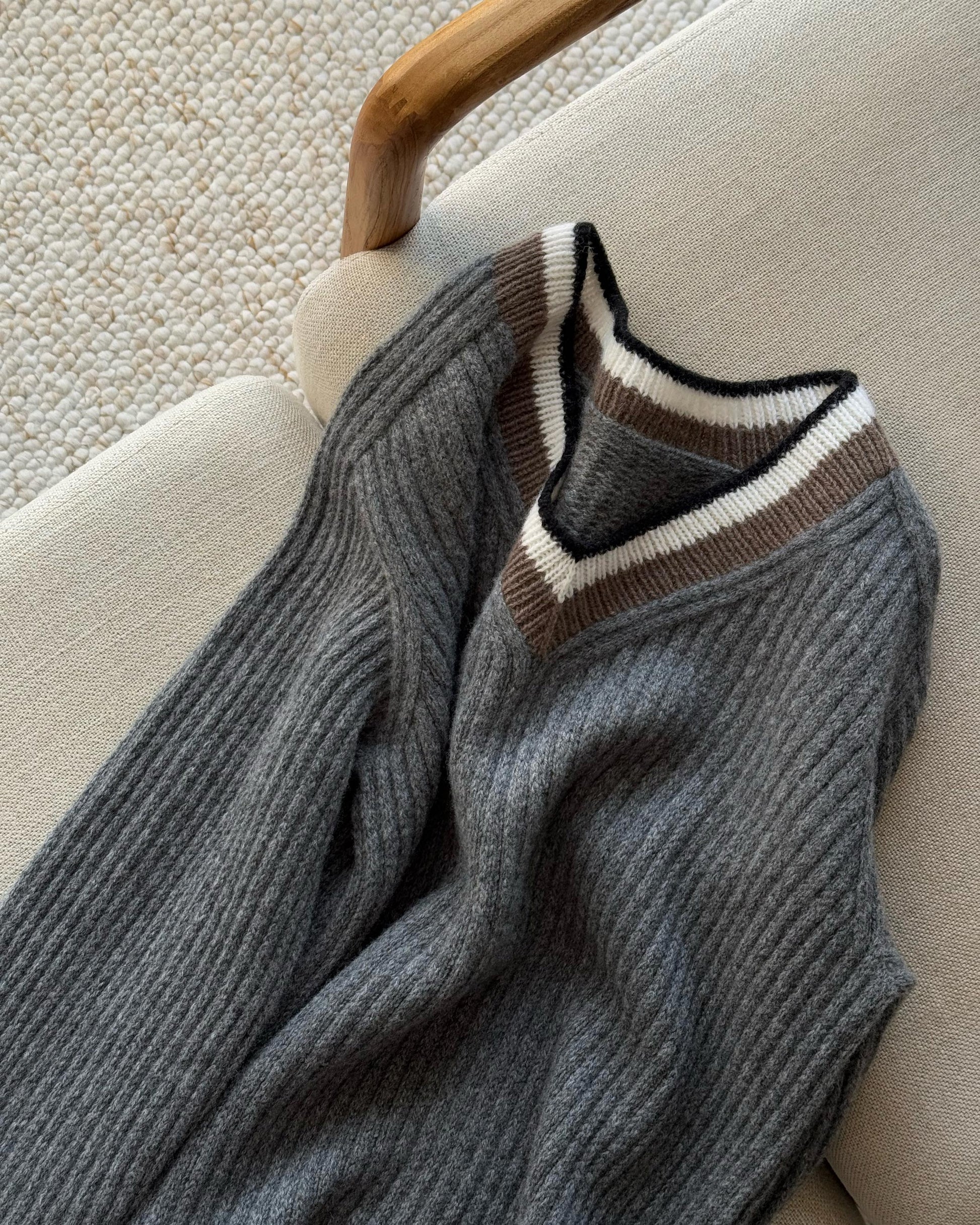 Relaxed fit sweater crafted in merino wool featuring V-neck and aesthetic design.