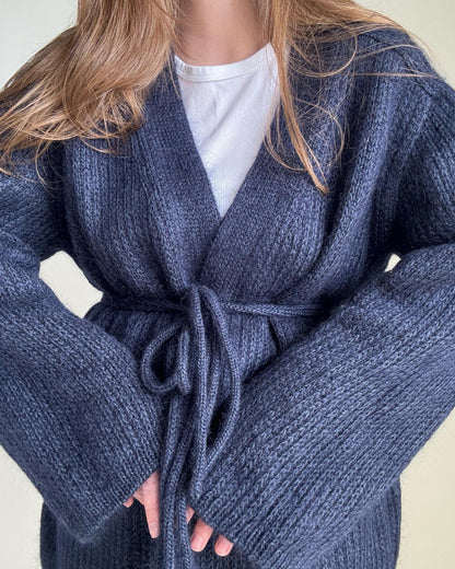 Feminine navy blue knitted cardigan featuring minimalist design elements.