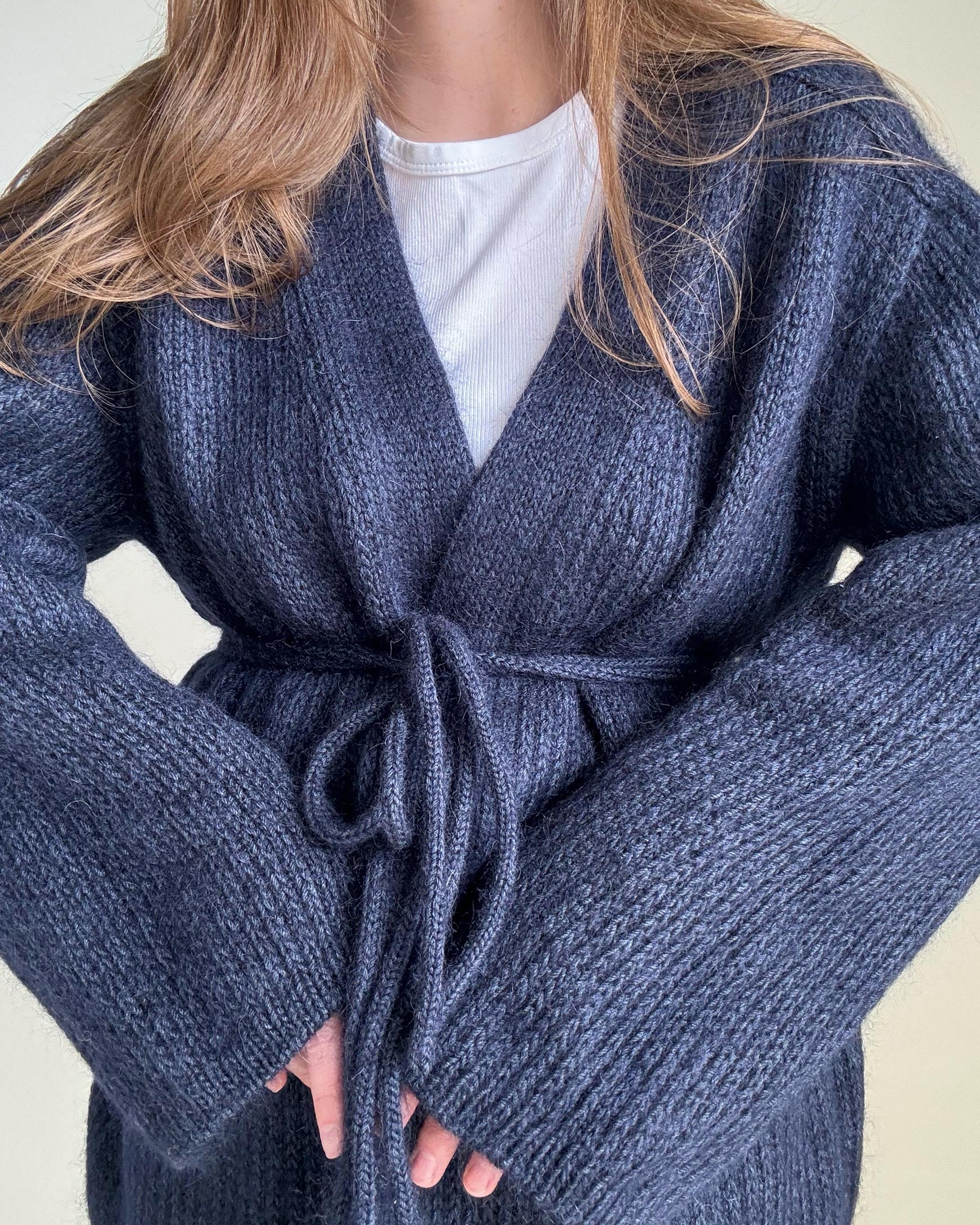 Die Fertigung eines raffinierten marineblauen Cardigans mit eleganten überschnittenen 