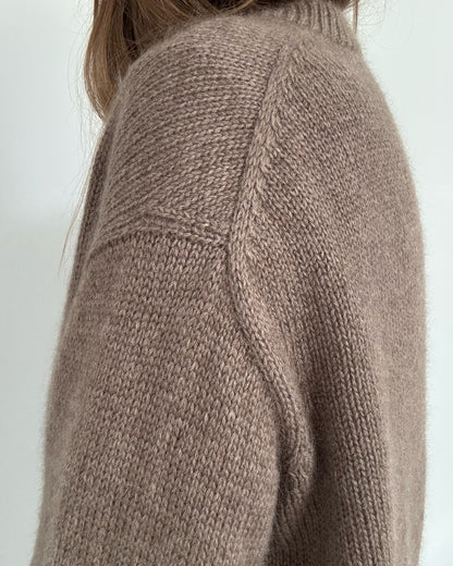 Hands in pockets image presents clean hem with double knitting rib and subtle slit shaping for movement.