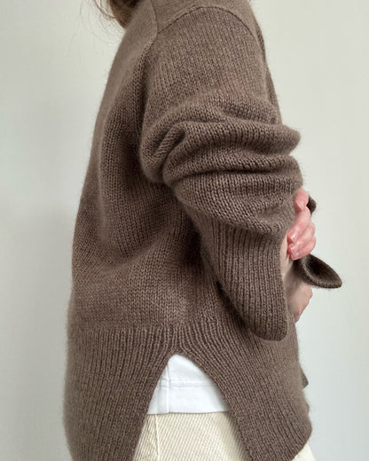 Overhead flatlay with Knit Blueprint and Knitting Instructions beside finished Ciro Sweater crewneck.