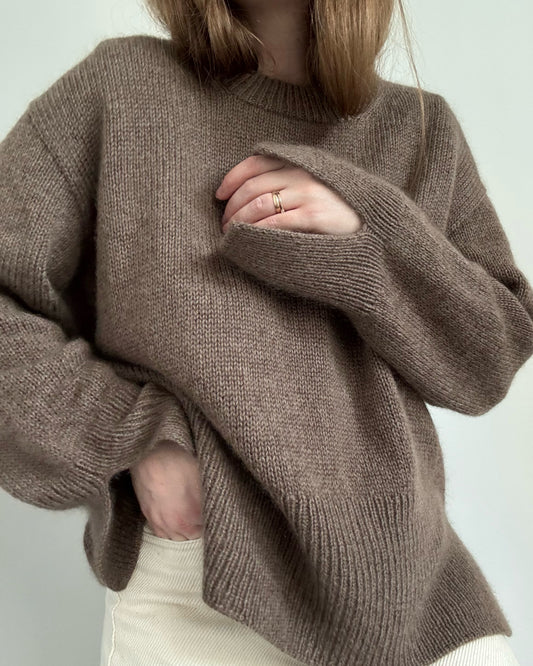 Back view documents smooth stockinette surface and classic basic silhouette in an aesthetic minimalist look.