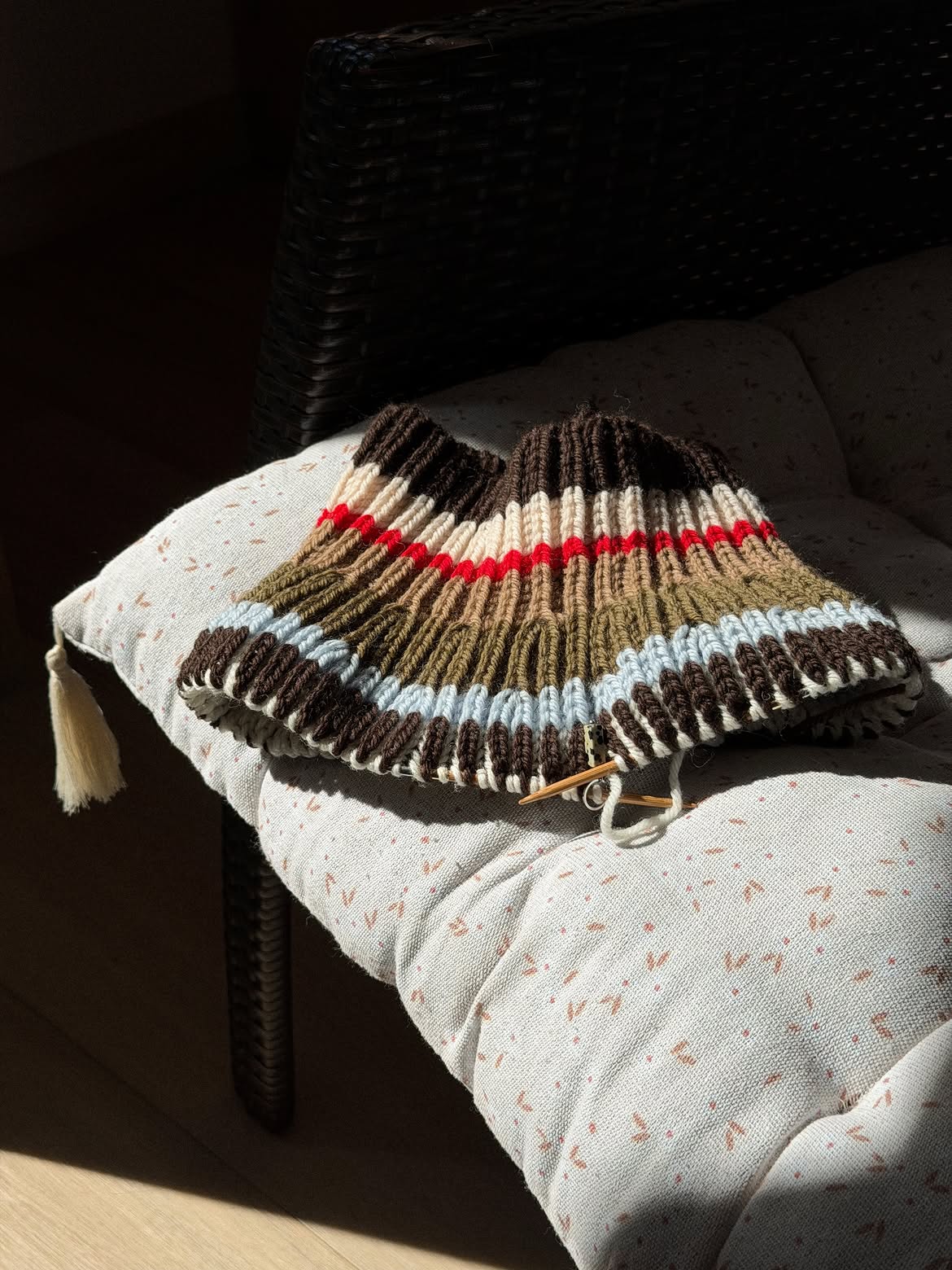 Front view of the striped capelet showing the high neck, compact length, and textured surface.