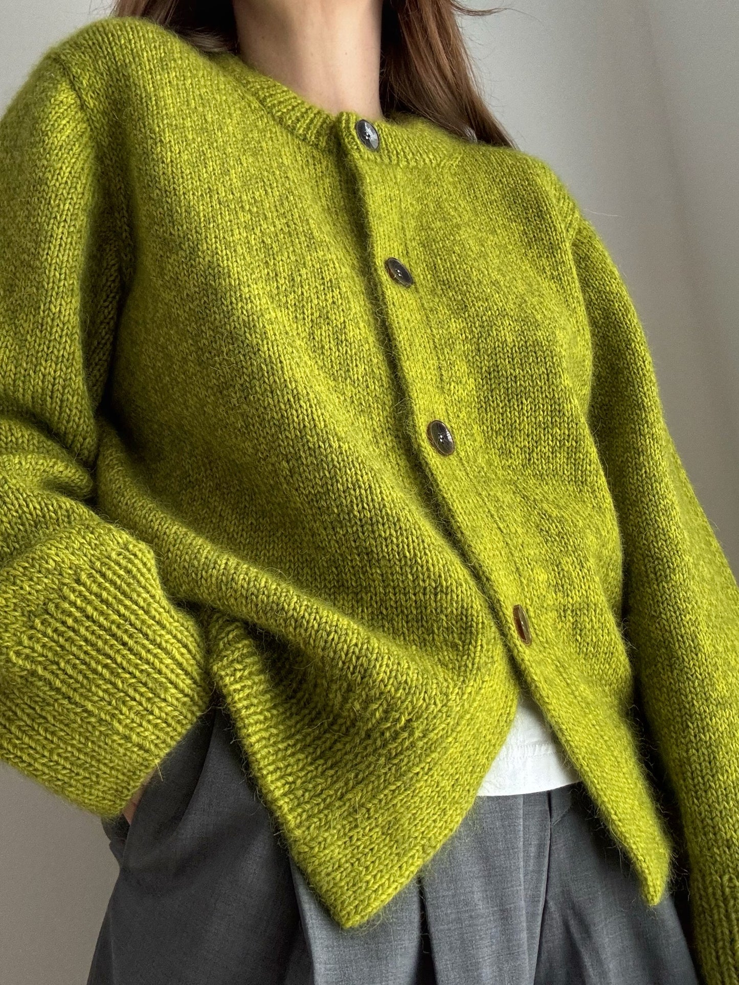 Knitwear instructions for a crewneck o neck cardigan with button up closure and regular button spacing.