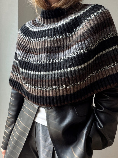 Side view of the capelet showing its short cape silhouette and softly flared lower edge.