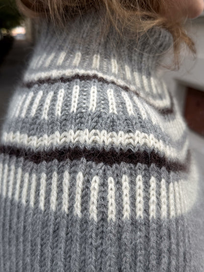 Side detail of the capelet showing how the fabric falls over the shoulder and upper arm.