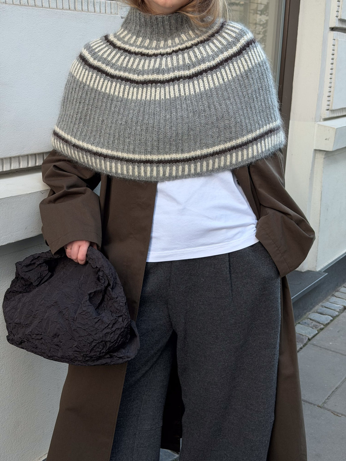 Three quarter back view showing the neck height and continuous textured fabric across the shoulders.