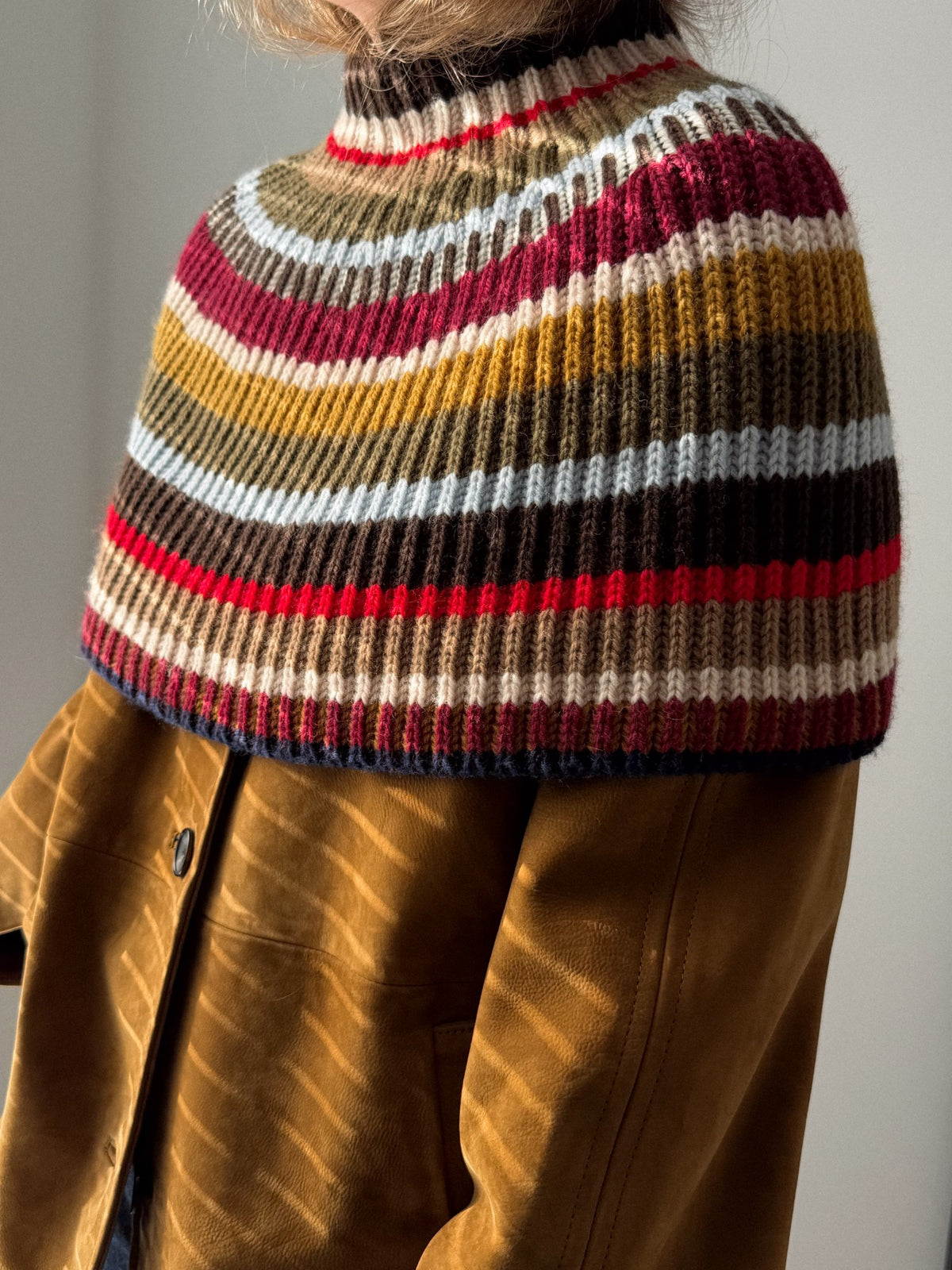Back view of the capelet showing the deep ribbed texture across the shoulders and back.