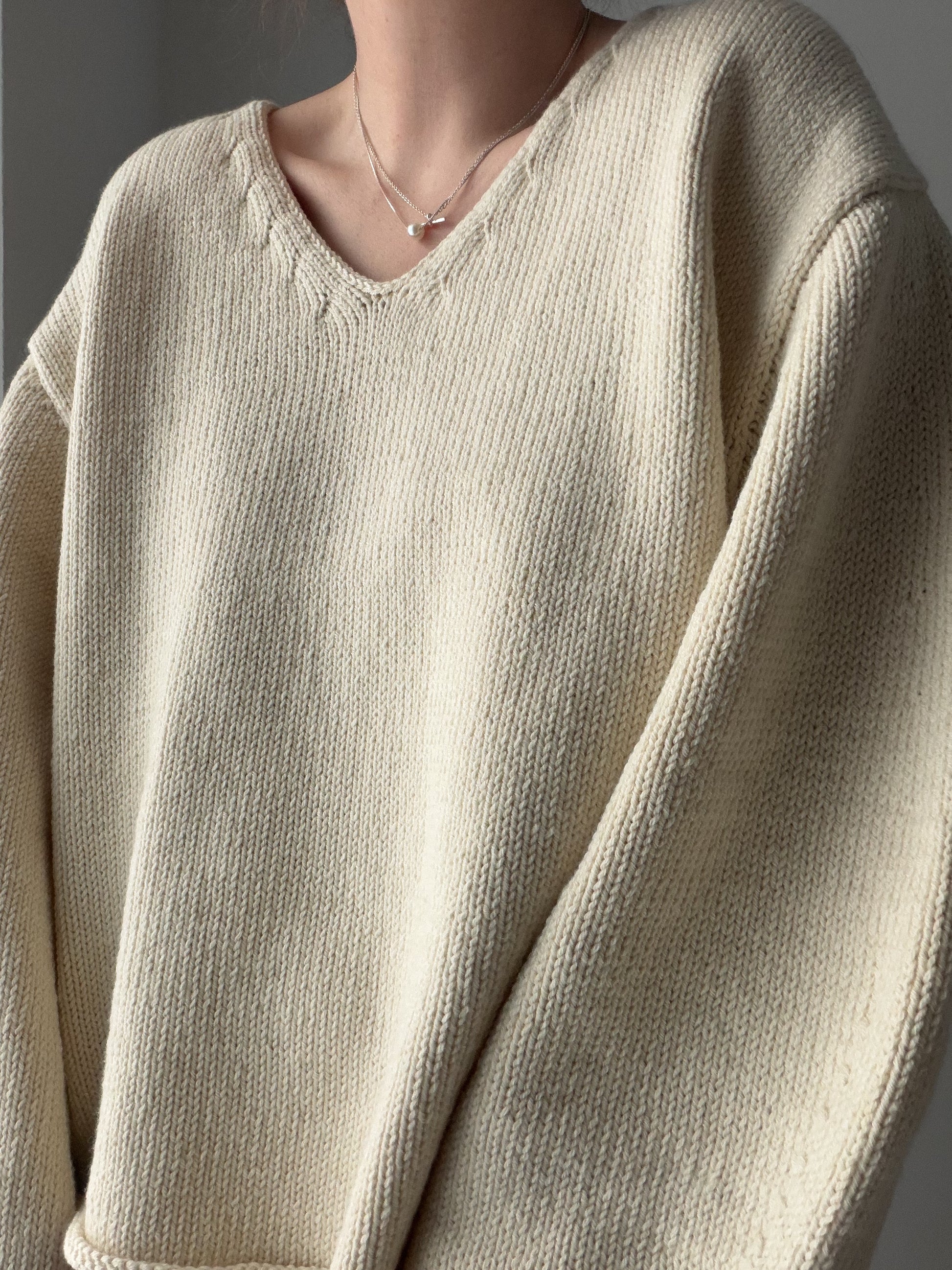 Phoenix Sweater porté dans une pose détendue, pull pour femme raffiné avec construction à épaules tombantes