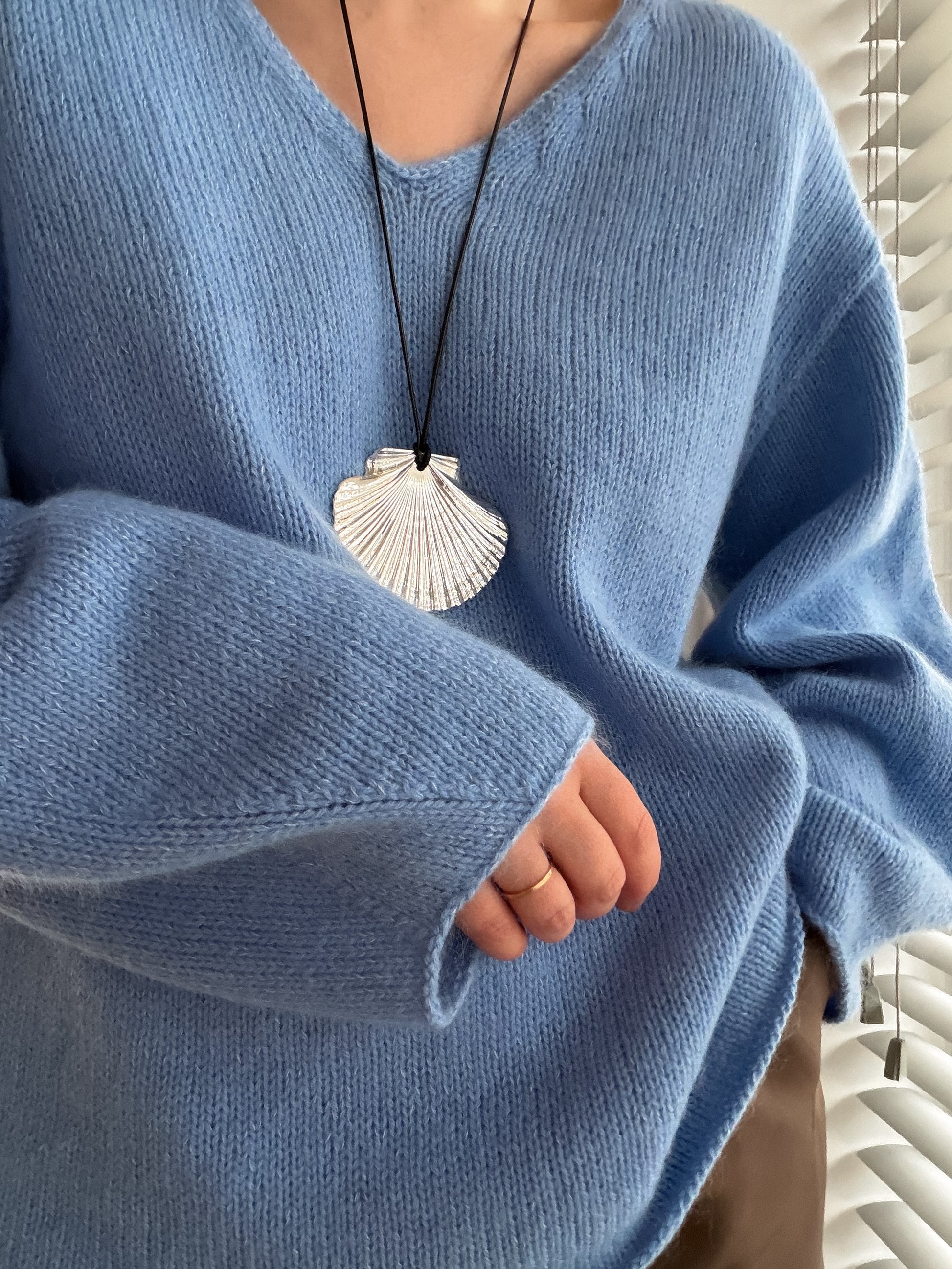 Gros plan sur le col en V du Phoenix Sweater, patron de blouse pour femme raffiné tricoté de haut en bas