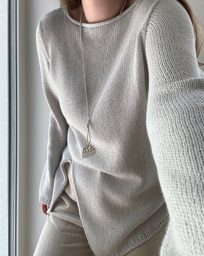 Bakvinkel avslører ren asymmetrisk forming og estetiske moderne linjer i Liv Blouse Knit Guide.