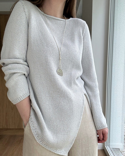 Front portrait captures regular fit drape and boatneck edge refined by craft focused knit blueprint.