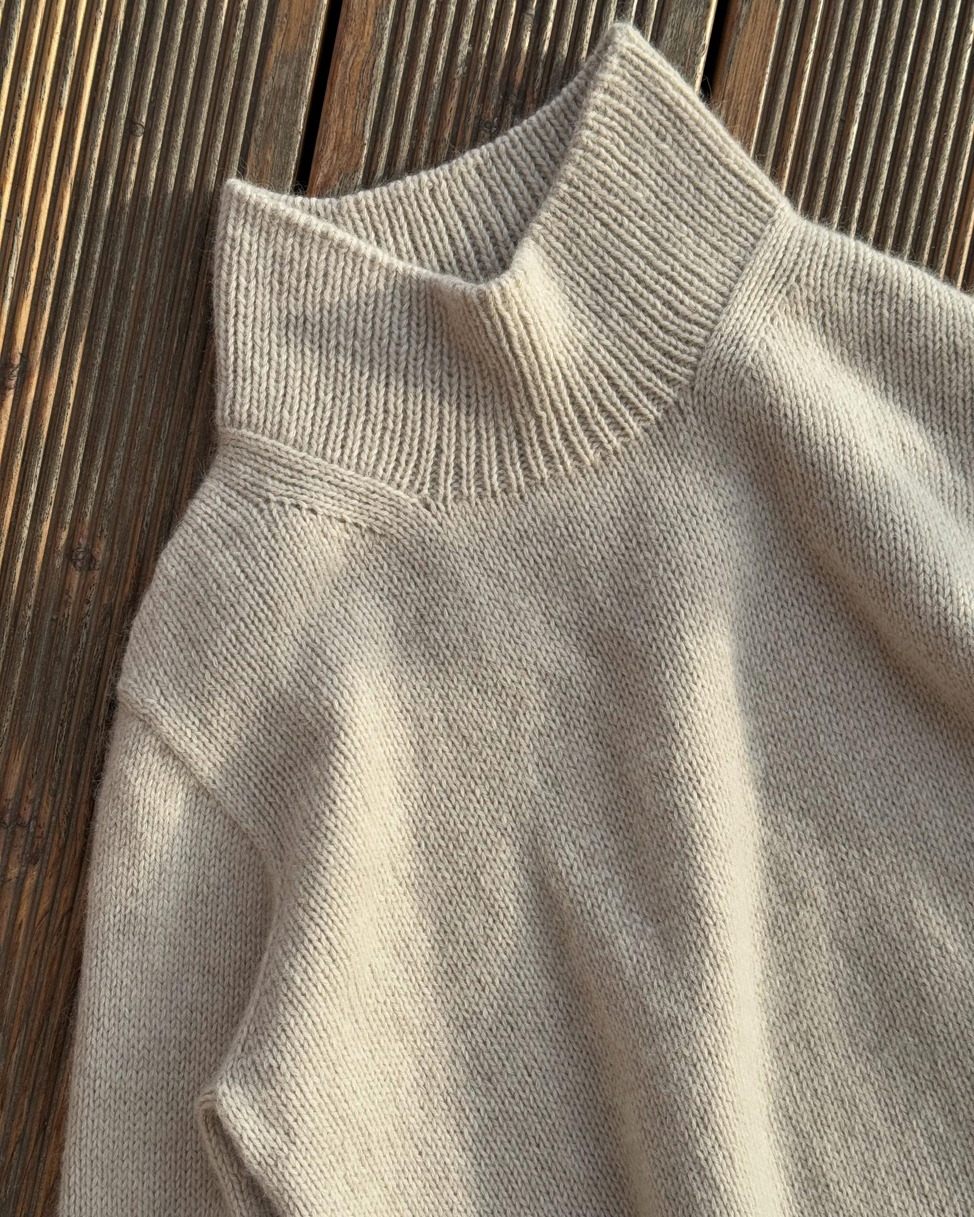 Turtleneck collar detail capturing the minimalistic style in alpaca wool.