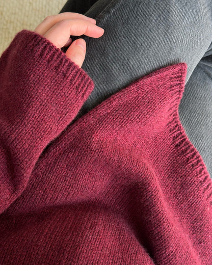 Top-down-strikket mock neck-sweater skabt med et forfinet glatstrik for en minimalistisk æstetik.
