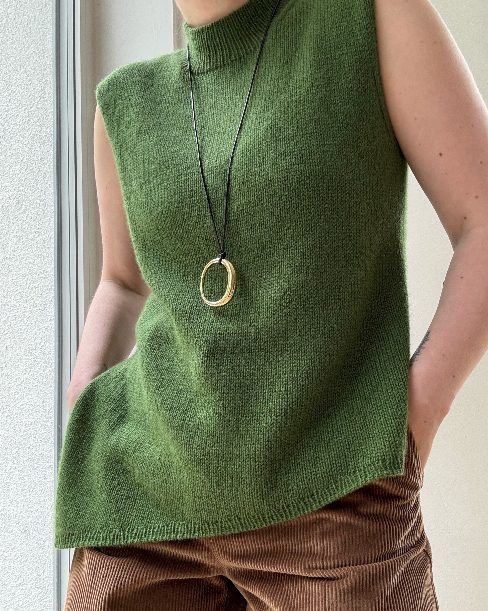 Gros plan met en valeur la texture de tricot aéré et le bord mock neck raffiné du modèle Liv Top intermédiaire.