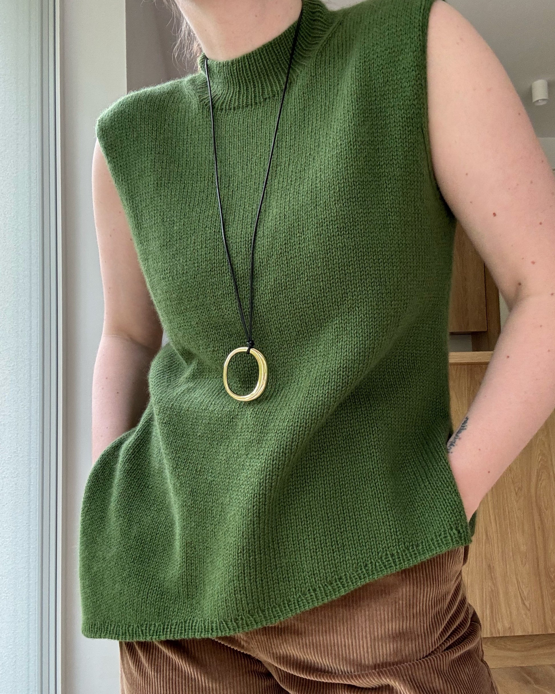 Detaljfoto fokuserar på övergång mellan mock neck och rund hals och skapar minimalistisk stil.