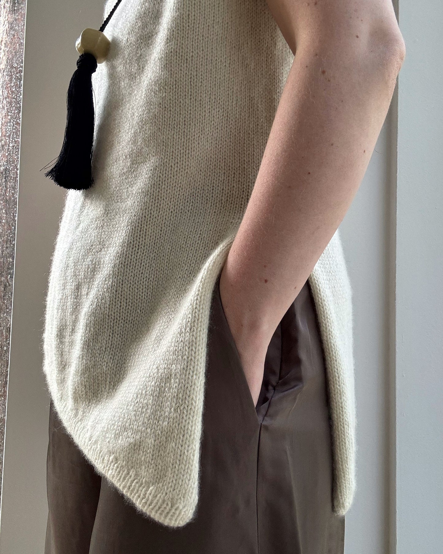 Mannekengfoto presenterer asymmetrisk skulderkonstruksjon i Liv Top strikkeguide for damer.