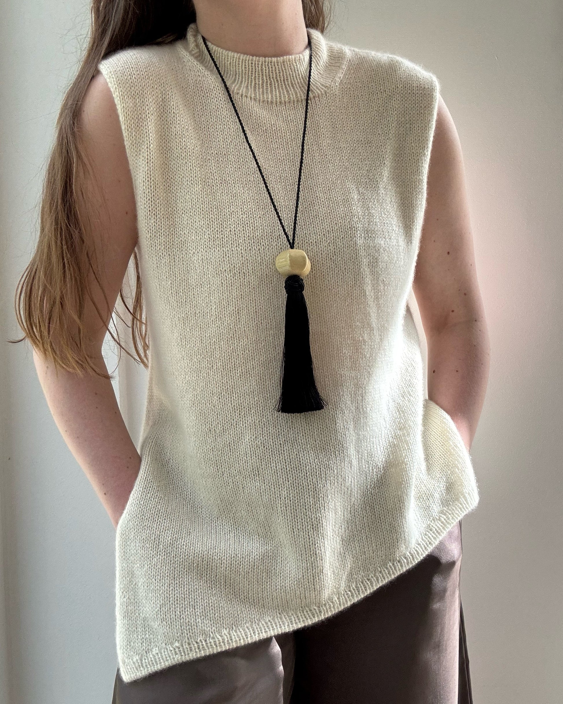Närbild framhäver gles stickstruktur och raffinerad mock neck kant på Liv Top mönstret för medelnivå.