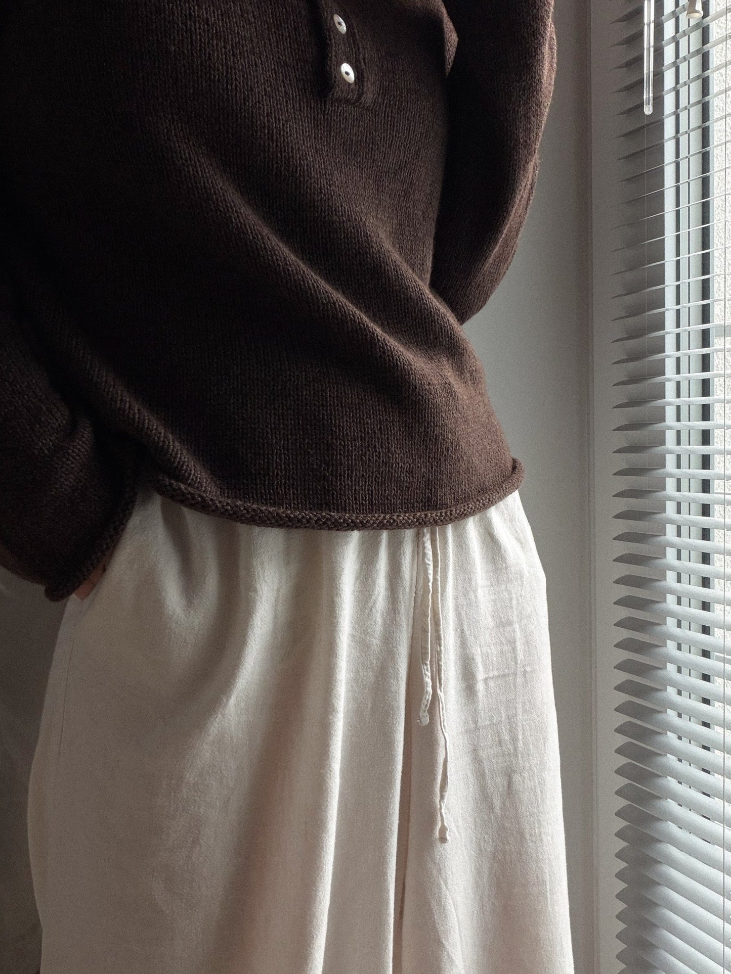 Mia Blouse genseren i sport weight garn vist fra en trekvart vinkel med en klassisk avslappet form.