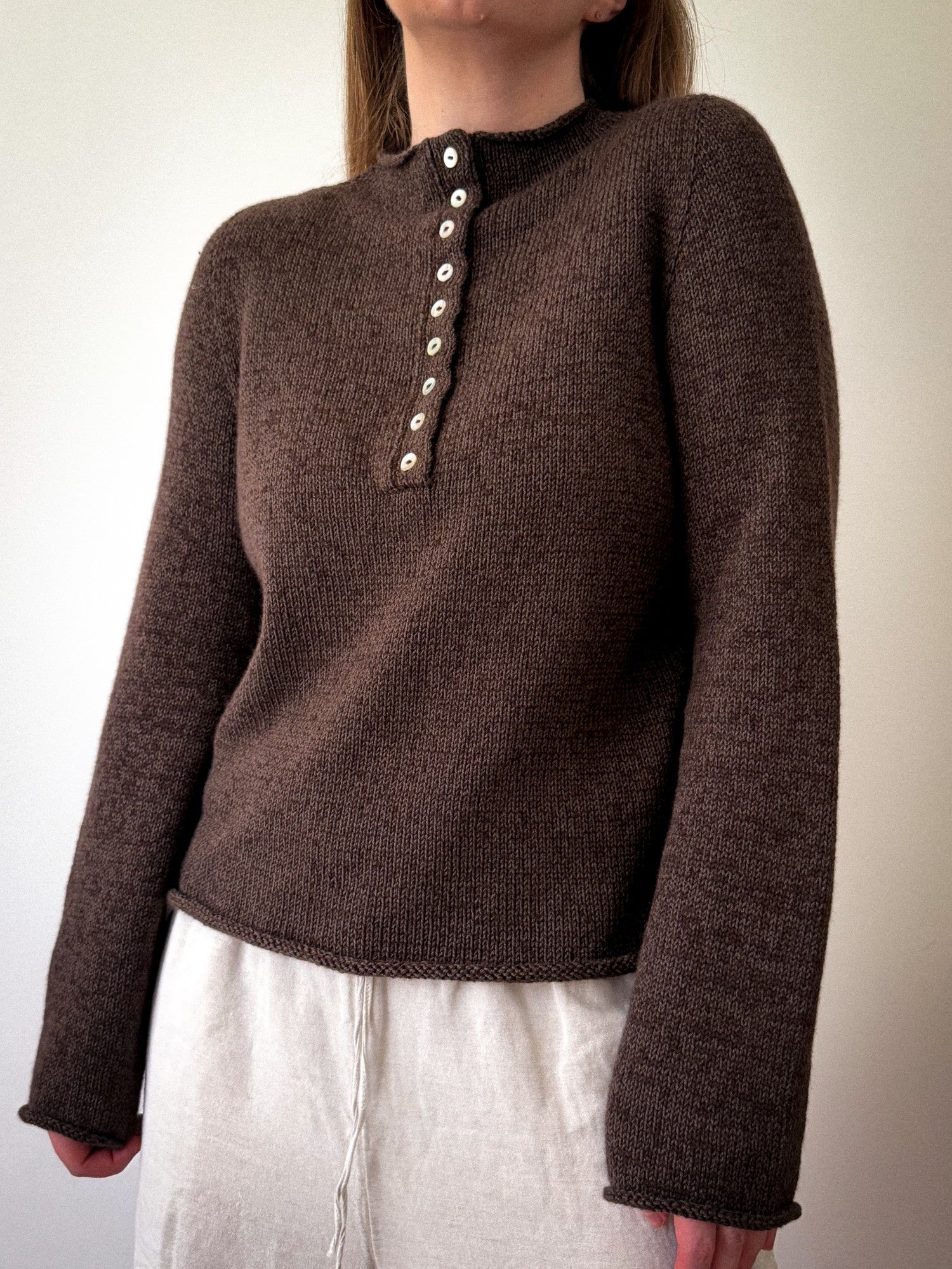 Mia Blouse pullover shown in a relaxed pose, featuring top down construction and a soft minimalist aesthetic.
