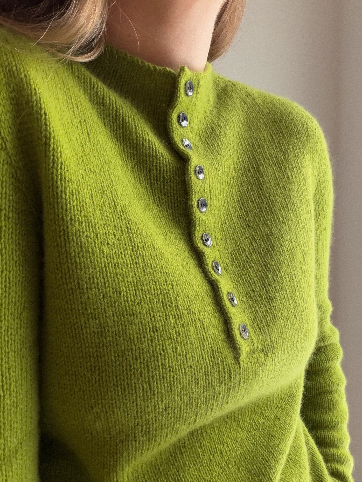 Detalj av framsidan på Mia Blouse med polokrage, slätstickning och ren knäppning framtill.