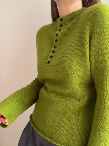 Minimalistische Damenstrickmode nach dem Mia Blouse Muster mit Rollkragen und Knöpfen an der Vorderseite.