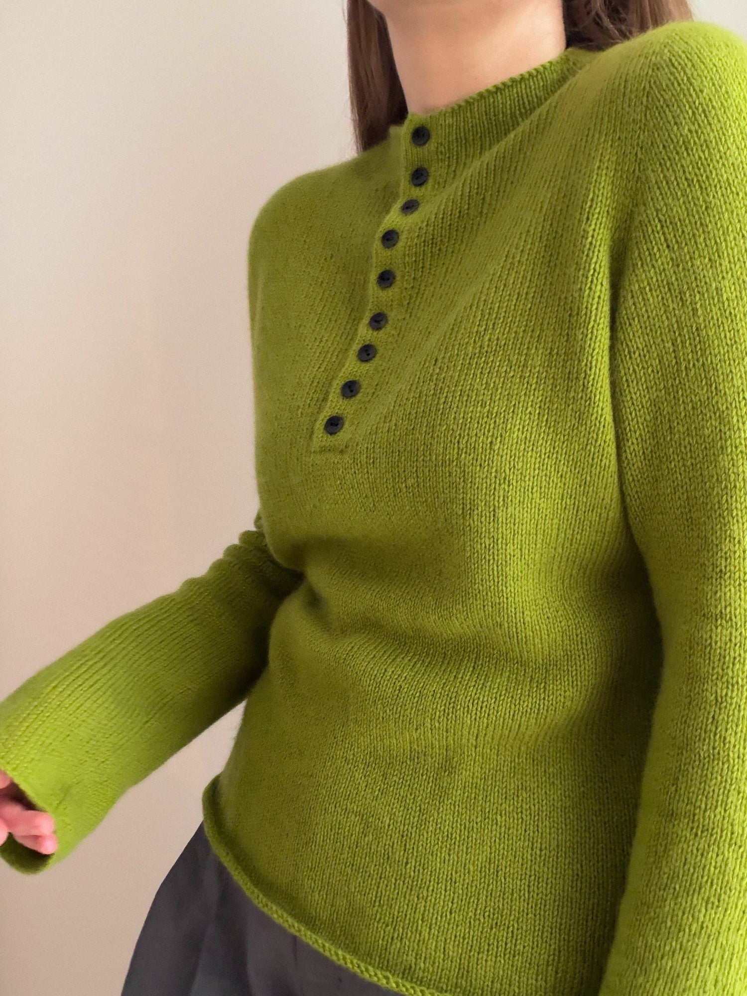 Minimalistisk strik til kvinder efter Mia Blouse opskriften med rullekrave og knapper foran.