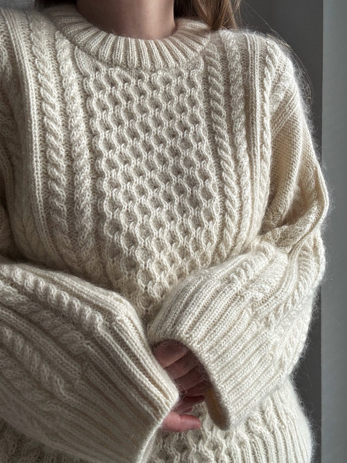 Ninon Sweater knitting pattern highlighting cable knitting and stockinette stitch contrast