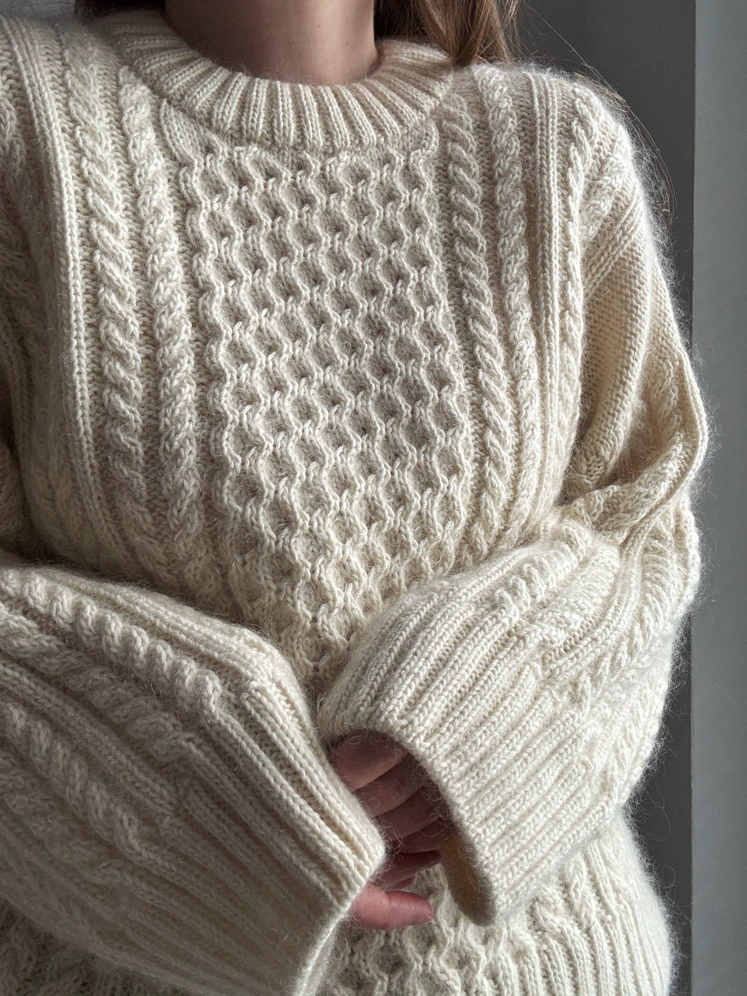 Ninon Sweater knitting pattern highlighting cable knitting and stockinette stitch contrast