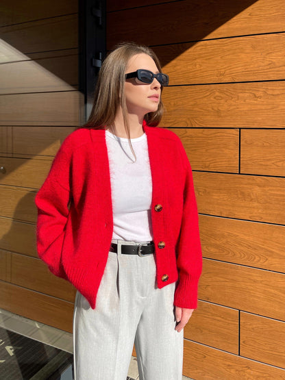 Woman wearing the Paul Cardigan in red, styled to show off its contemporary and classic elements
